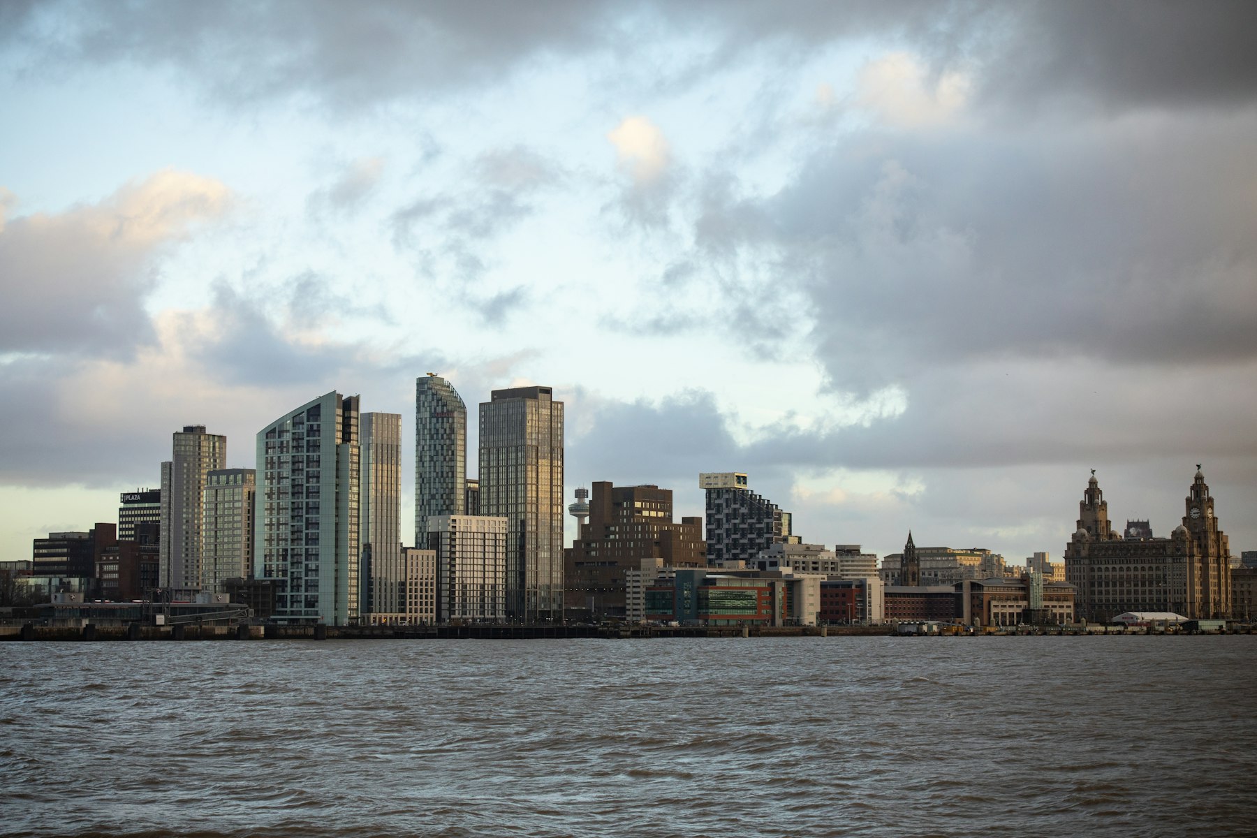 The Liverpool skyline seen across the River Mersey under a dramatic sky